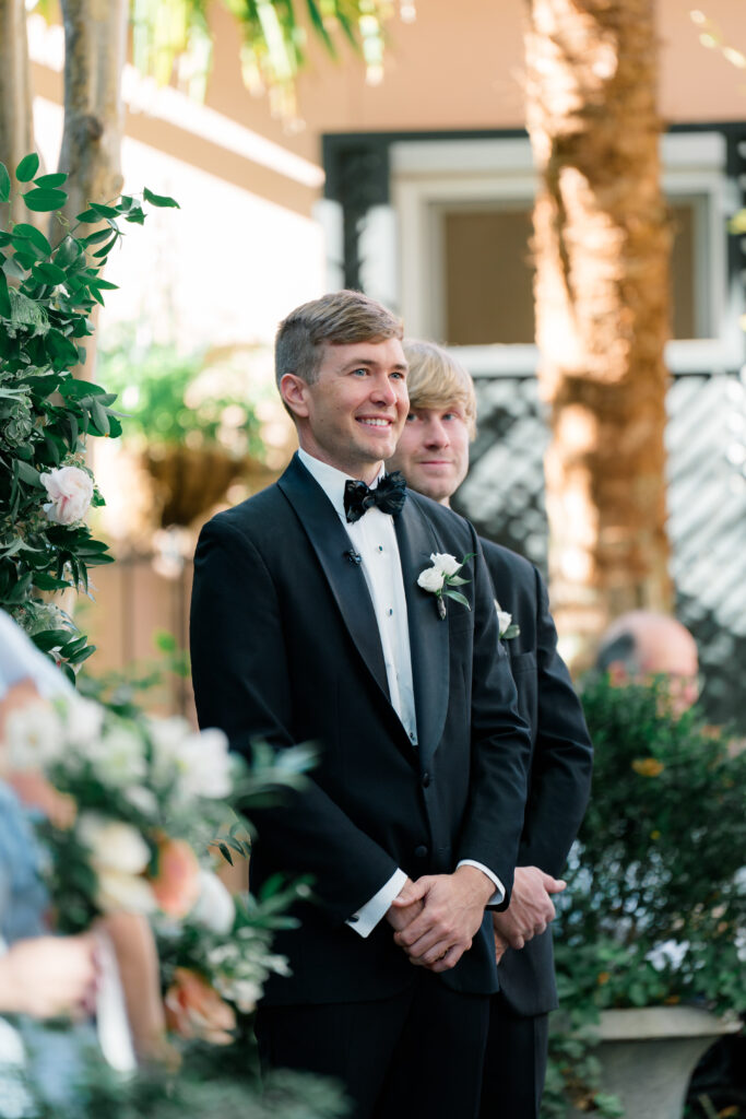 Groom sees bride for first time when walking up the aisle at wedding ceremony. 