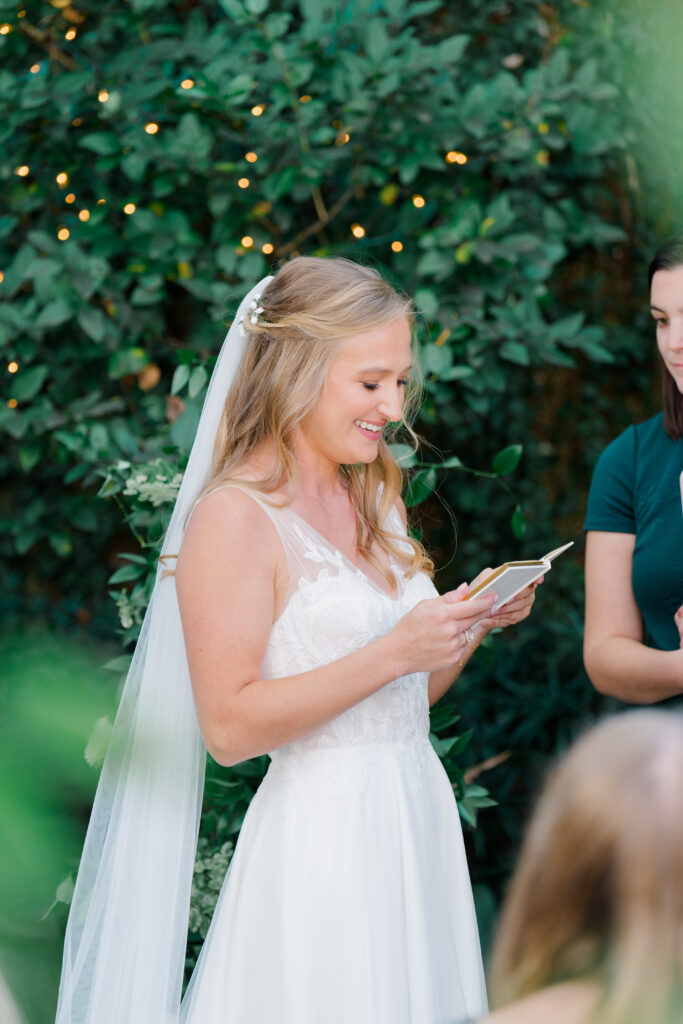 Bride reads her vows to groom during wedding ceremony. 