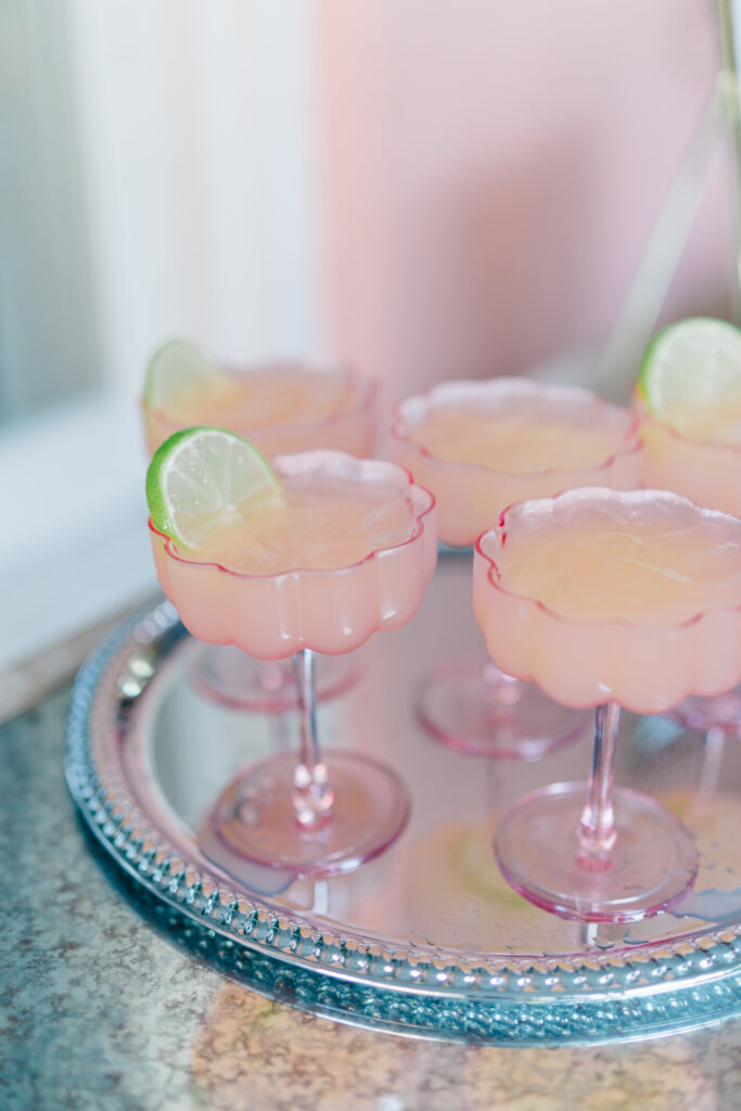Clear pink cocktail glasses with a lime garnish at Charleston wedding. 