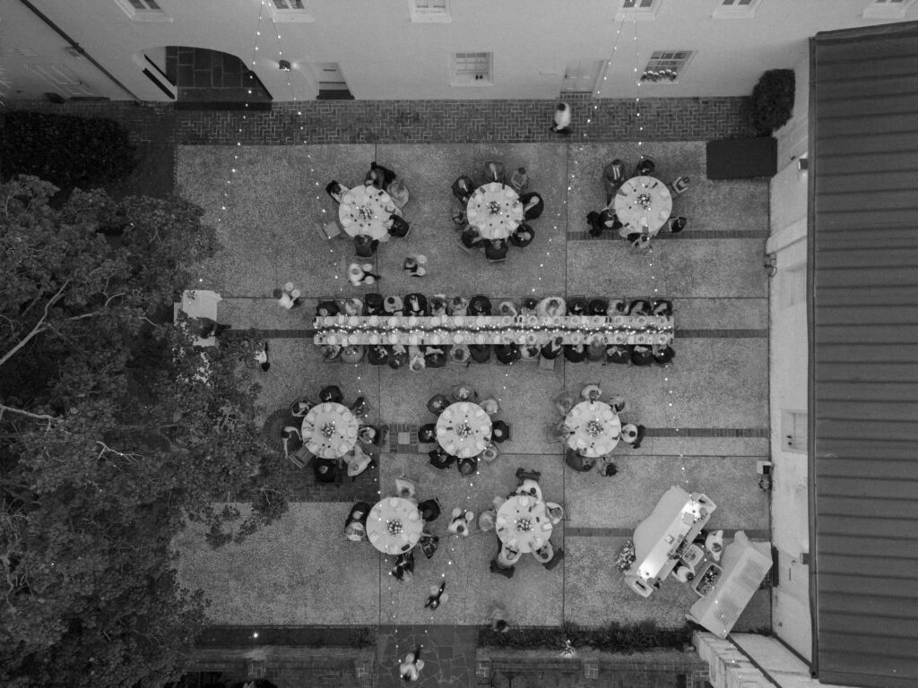 View from above of al fresco Charleston wedding reception dinner with string lights. 