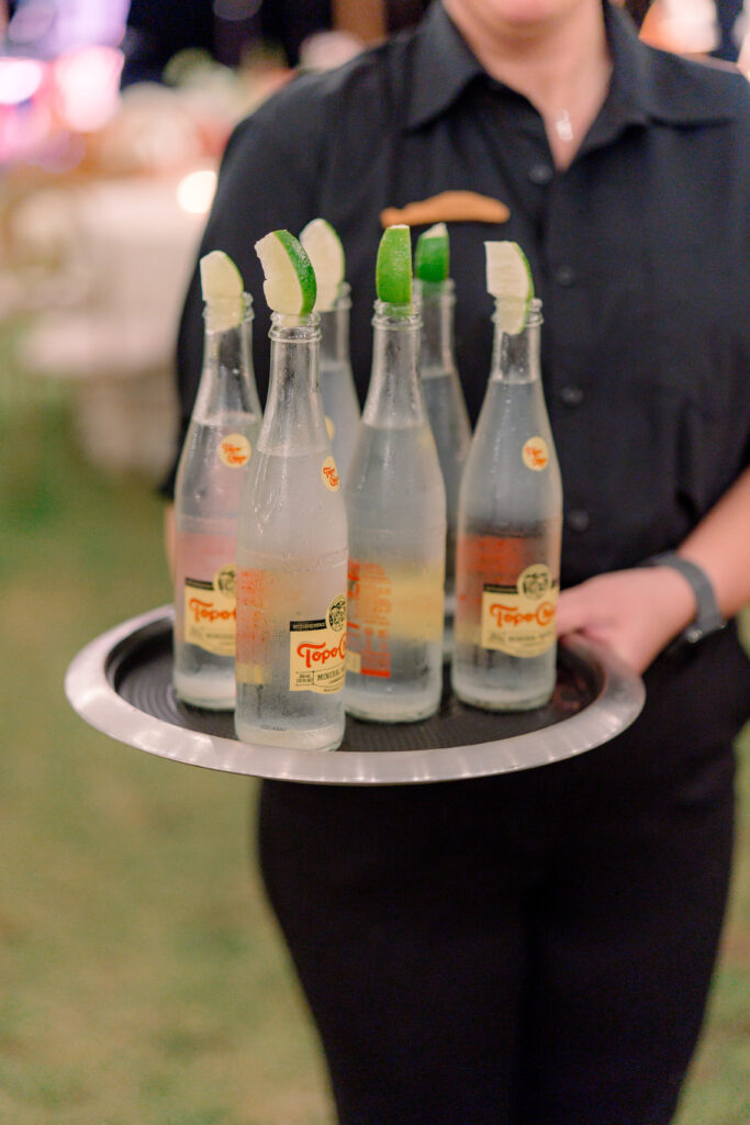 Topo Chico welcome cocktails. Server holding a tray of drinks and waiting for guest to arrive. 