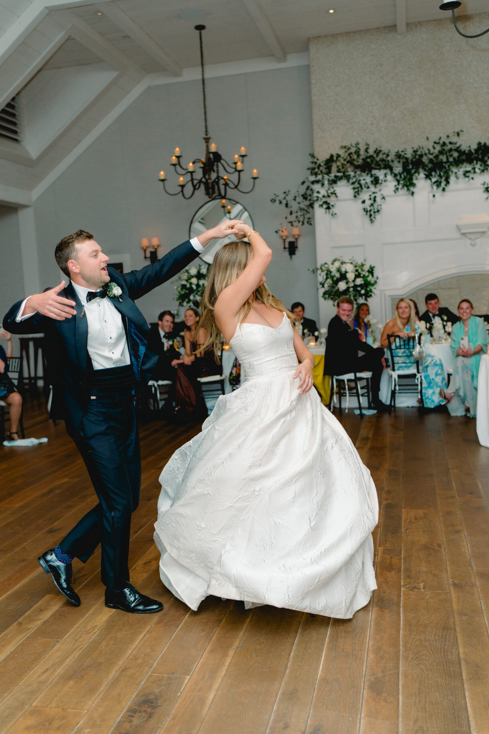 Groom spins bride at wedding first dance. 