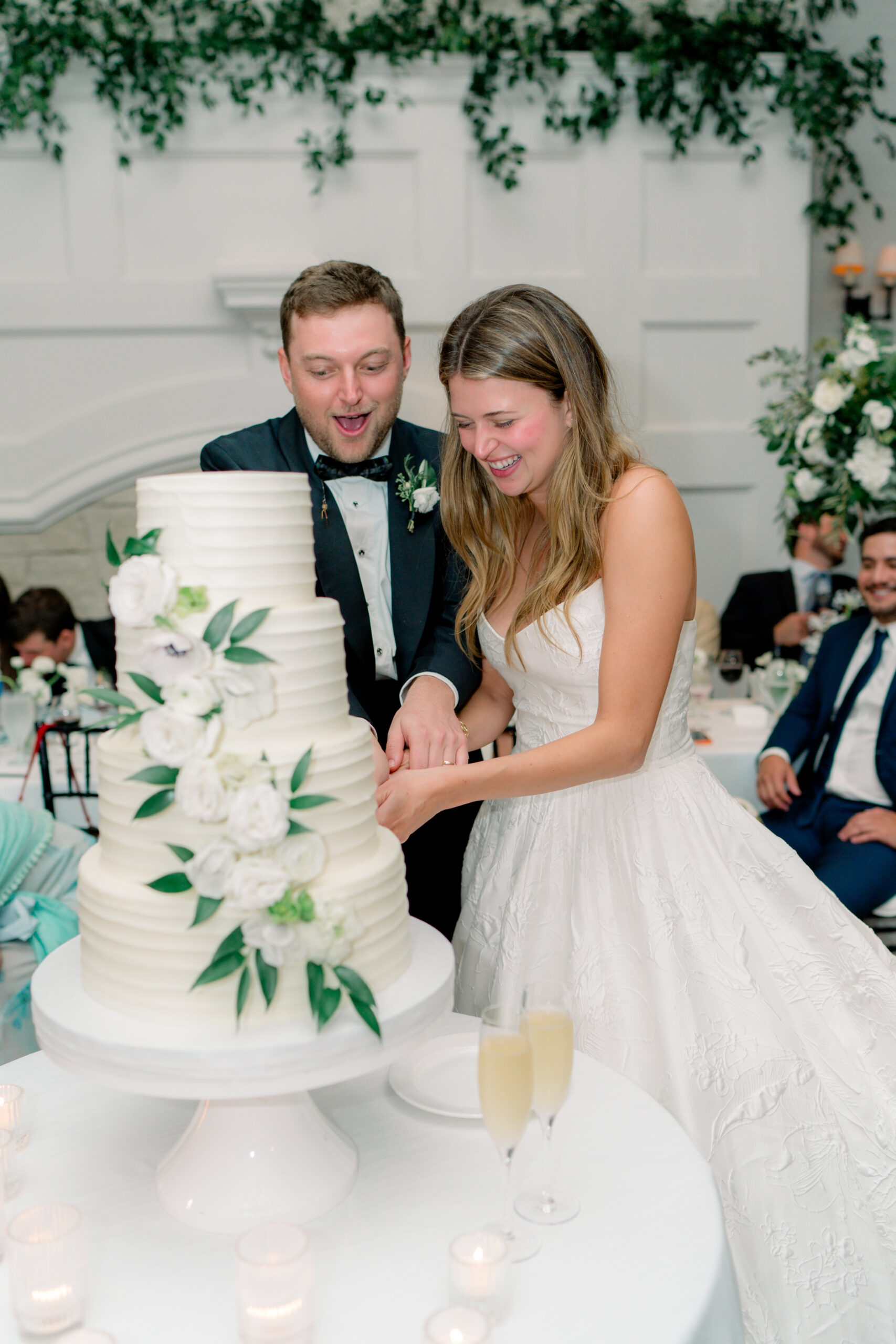 Bride and groom have fun with cutting the cake at their wedding reception. 