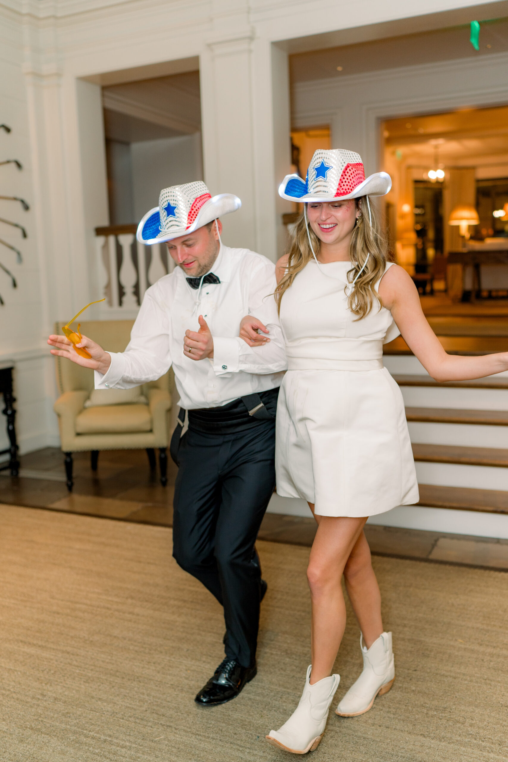 Texas bride and groom fun stetson party hats. Walking to the beat. 