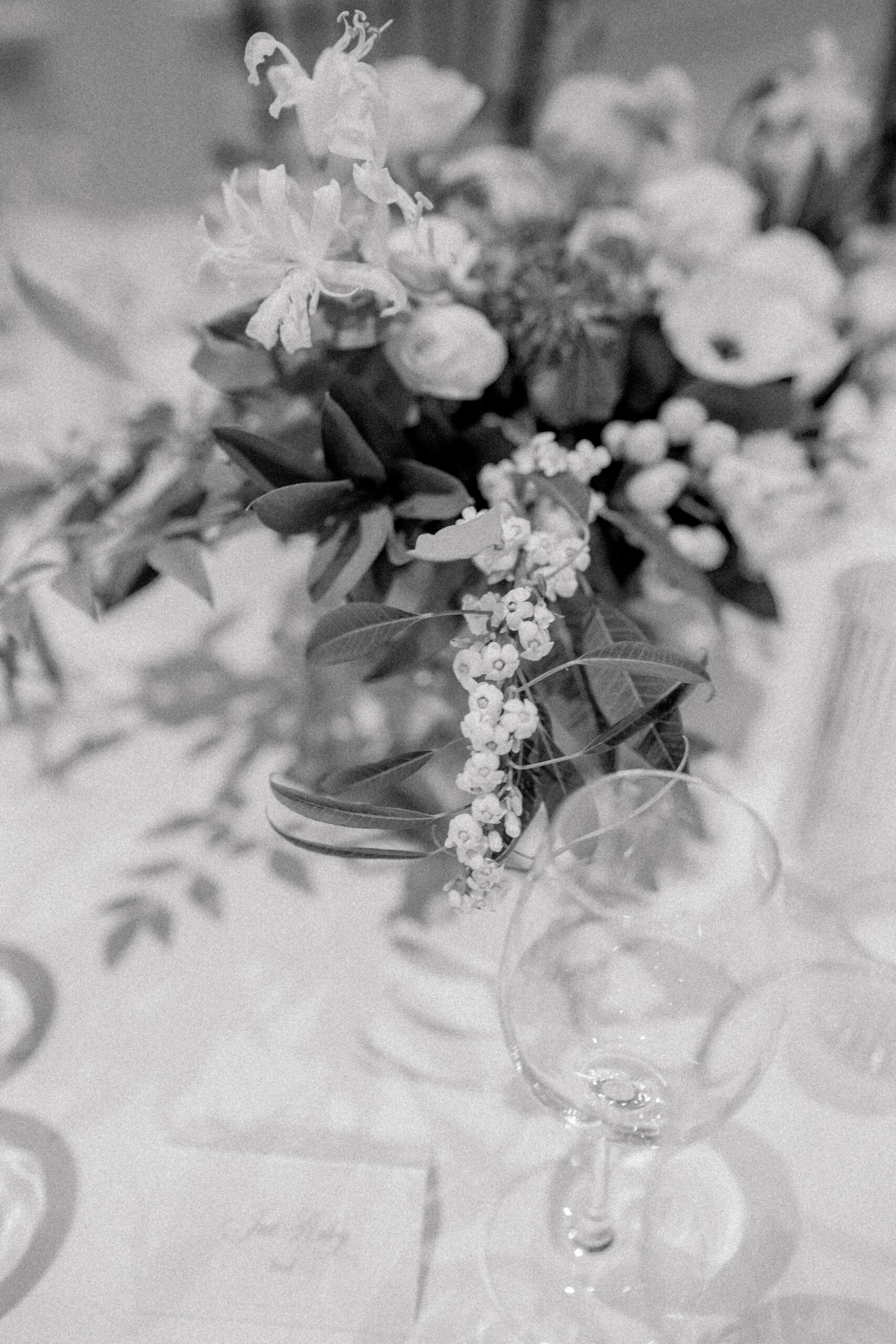 Black and white photo of low table top wedding reception flowers. 
