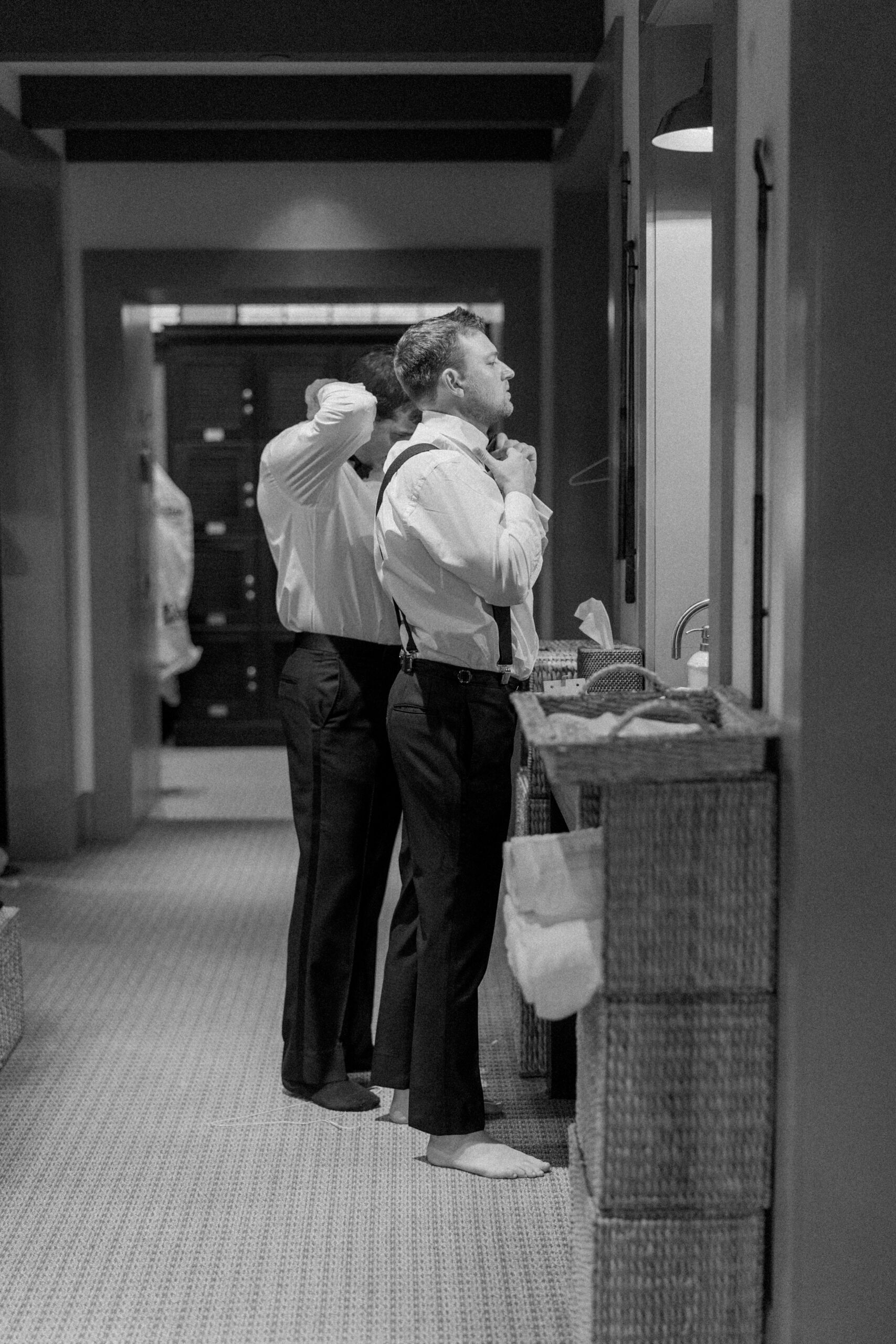 Groom getting ready in the mens locker room at the River Course Kiawah. Black and white wedding photo. 