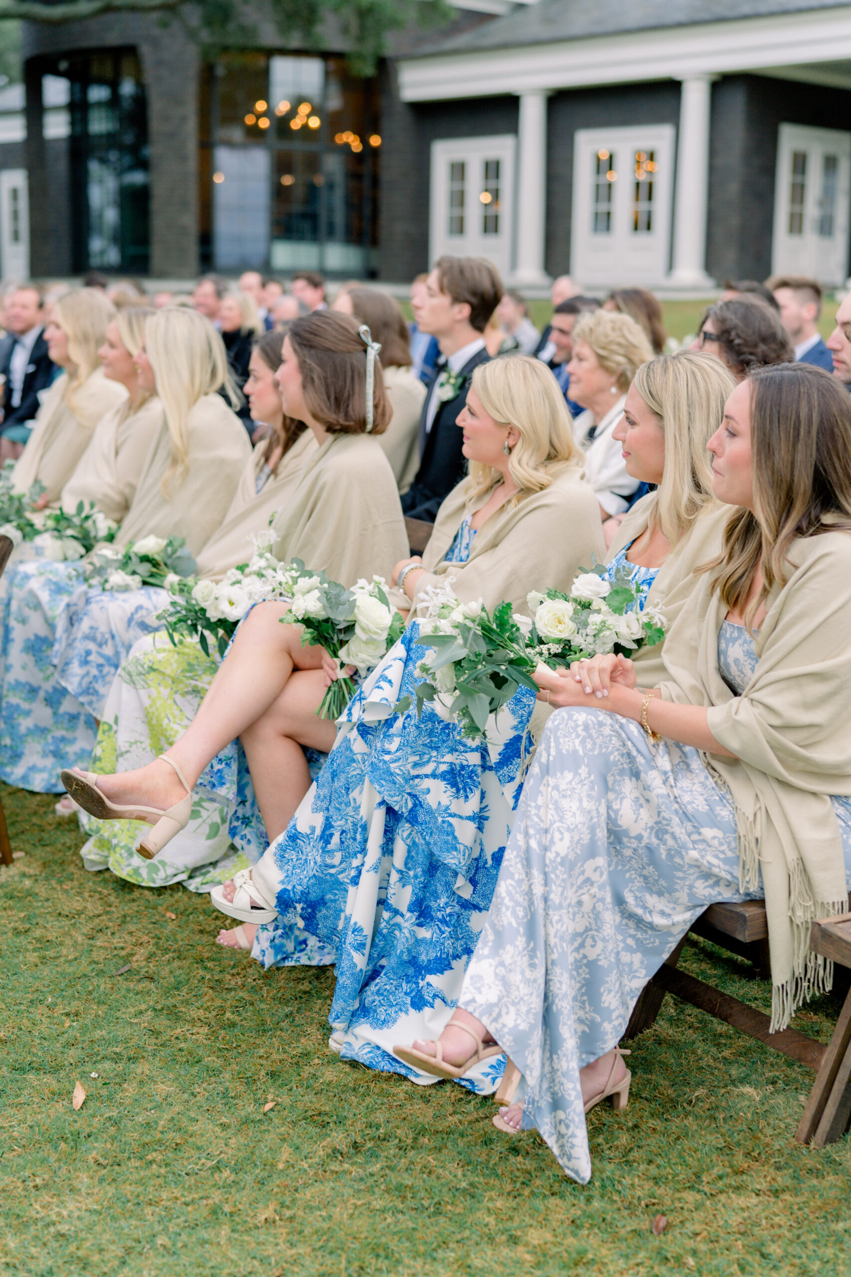 Bridesmaids cover their shoulders with pashminas during chilly waterfront wedding ceremony in Charleston. 