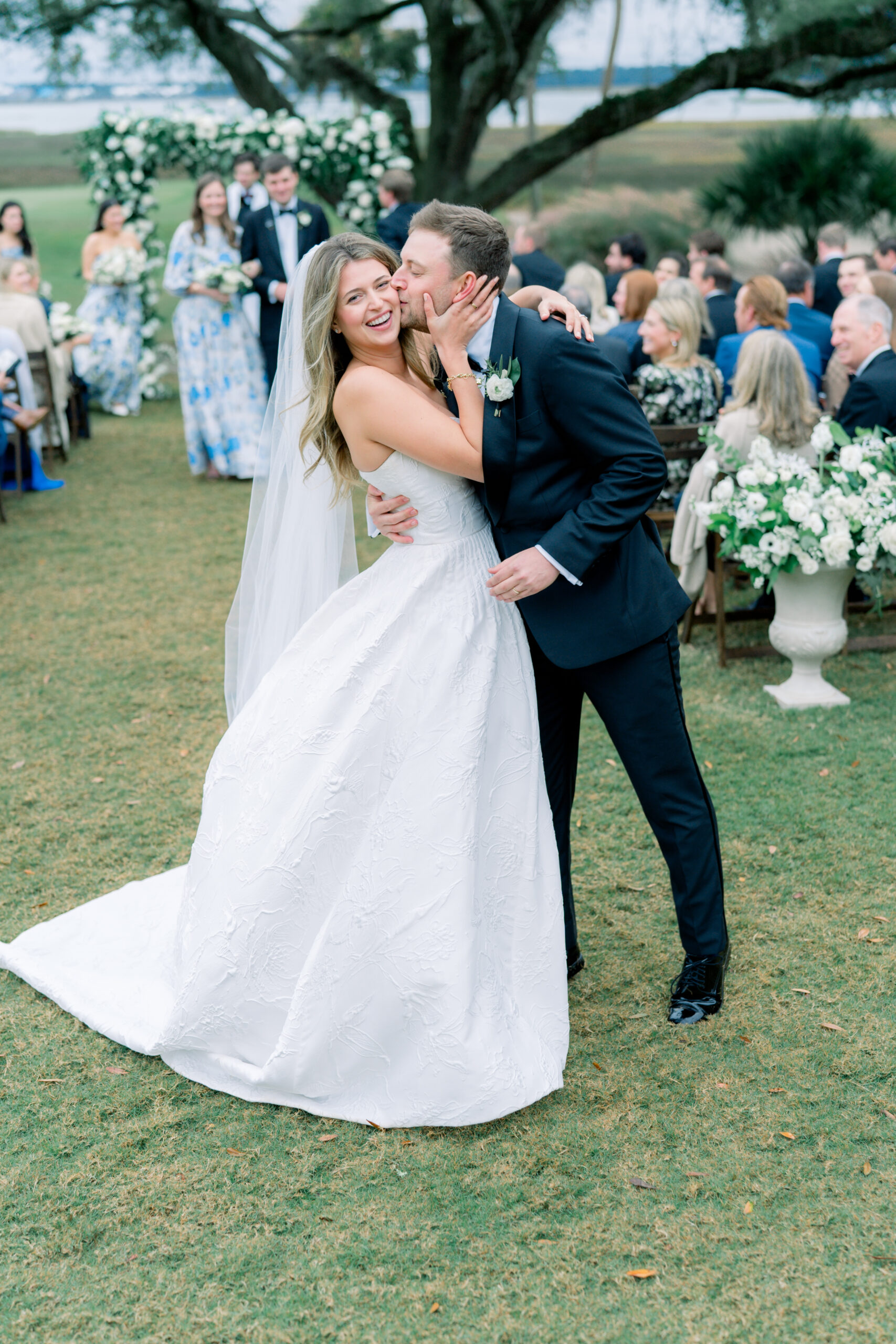 Groom kisses brides cheek after exiting wedding ceremony. Charleston fall wedding. 