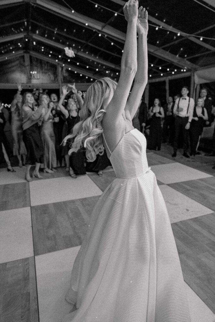 Black and white photo of bouquet toss. 