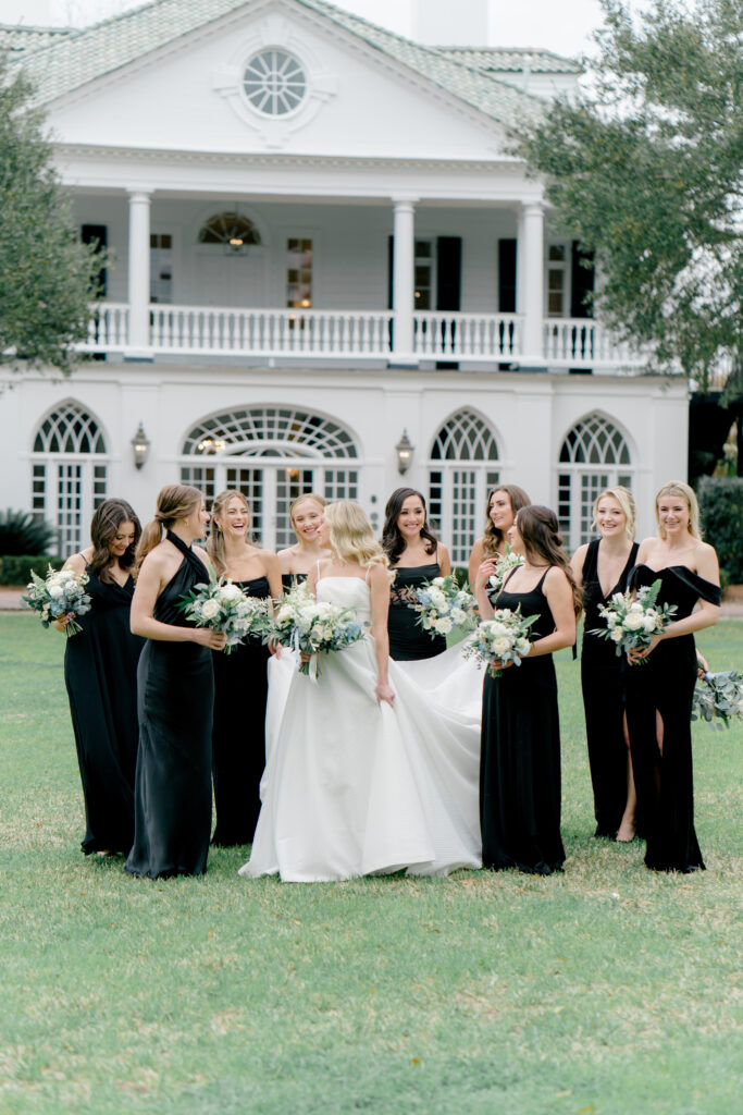 Bridesmaids walking with bride. Bridesmaids in black dresses. Photographer charleston