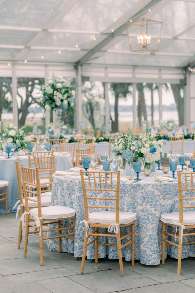 Blue floral table linens with tan chiavari chairs. Blue and white flowers. 