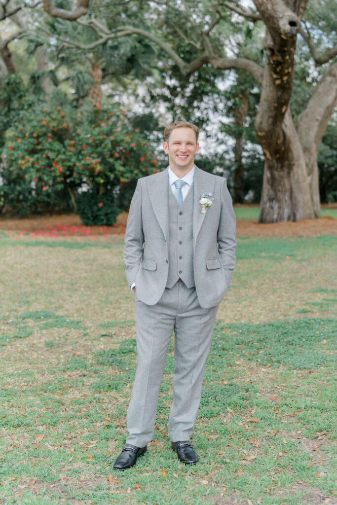 Groom in light gray three piece suit with light blue tie. 