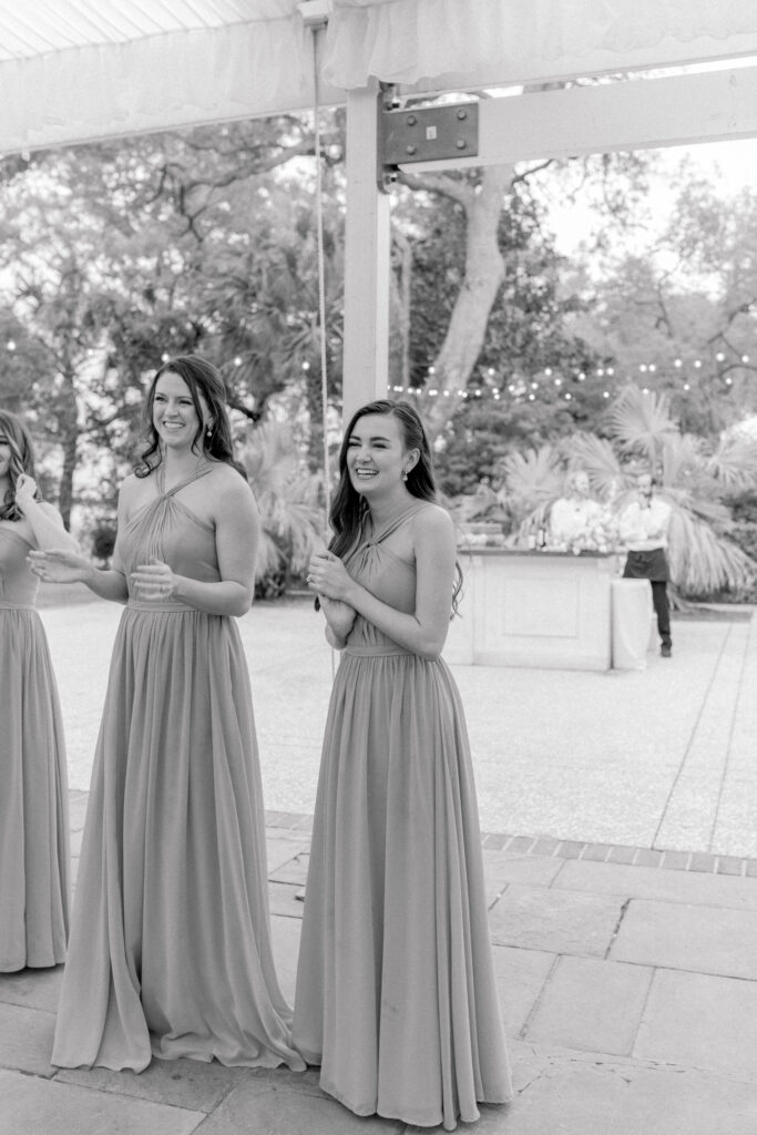 Bridesmaid laughing during bride and groom first dance. 