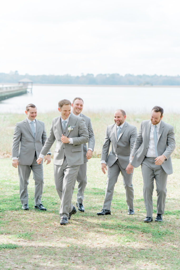 Groom and groomsmen by the water with Lowndes Grove dock in the background.