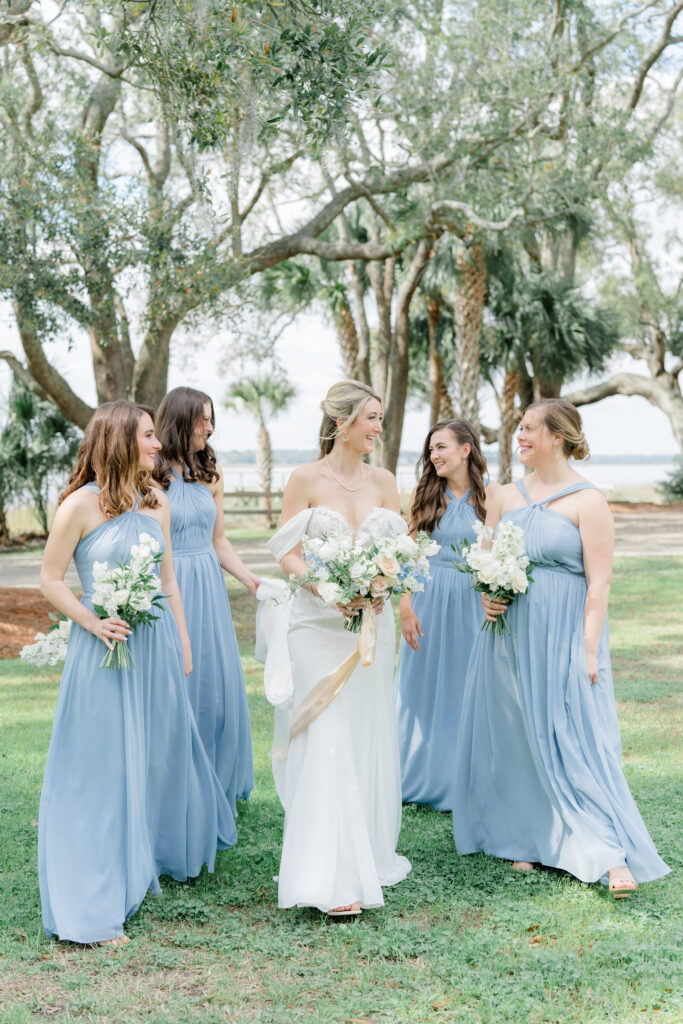 Bride standing with bridesmaids with palm trees in background. 