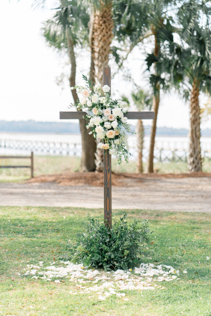 Wedding ceremony cross decorated with flowers. 