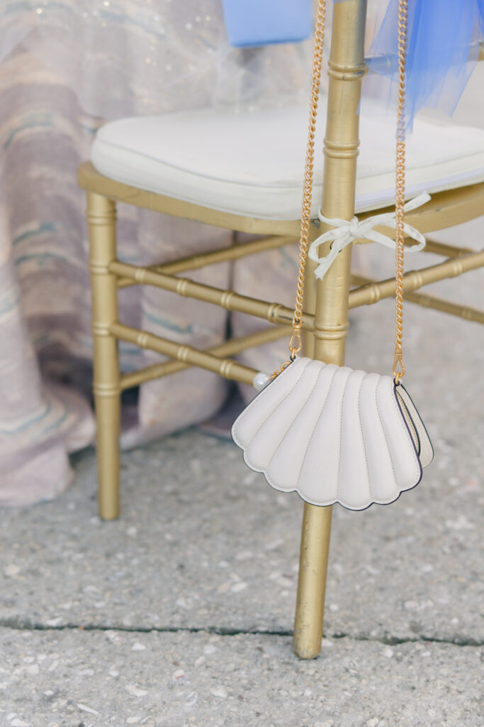 Brides seashell purse hanging on her chair.
