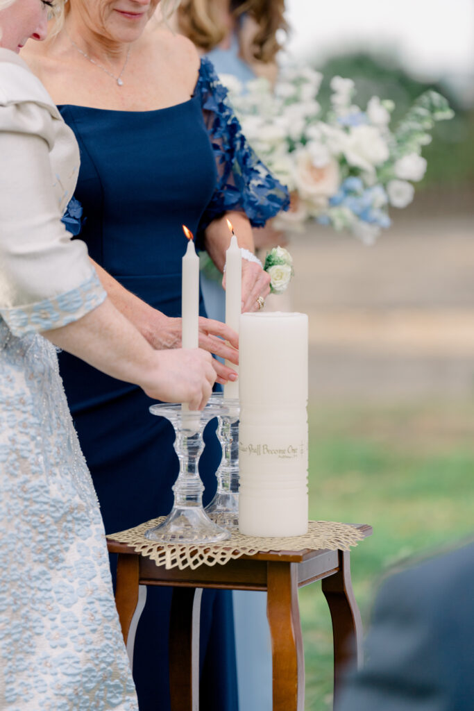 Mothers of the bride and groom light unity candle during wedding ceremony. 