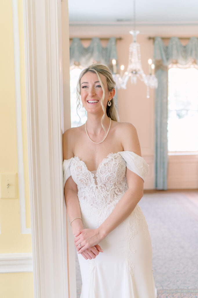 Blond Lowndes Grove bride leaning on the door upstairs. 