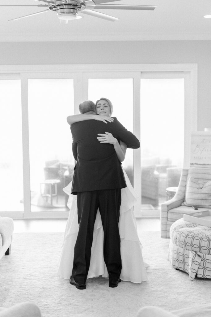 Bride hugs her dad after seeing him for the first time on wedding day.