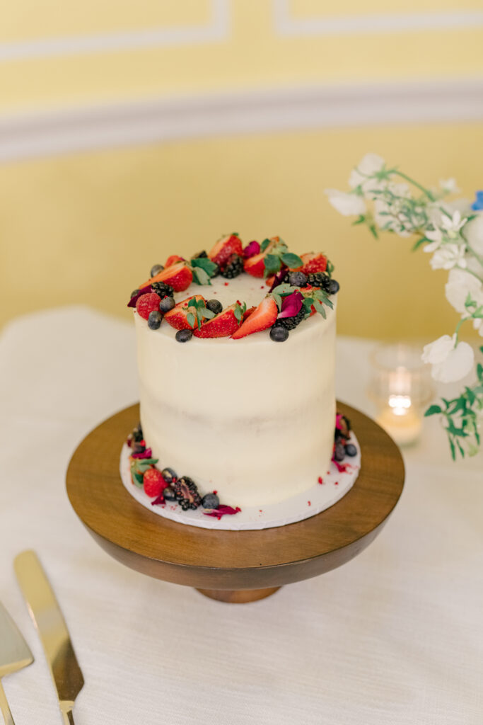 One-tier wedding cake with strawberries and blueberries.