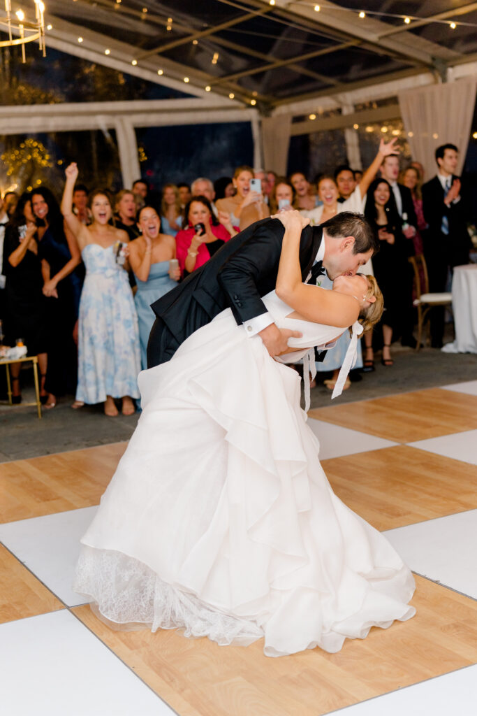 Charleston spring wedding reception bride and groom first dance dip kiss with string lights.