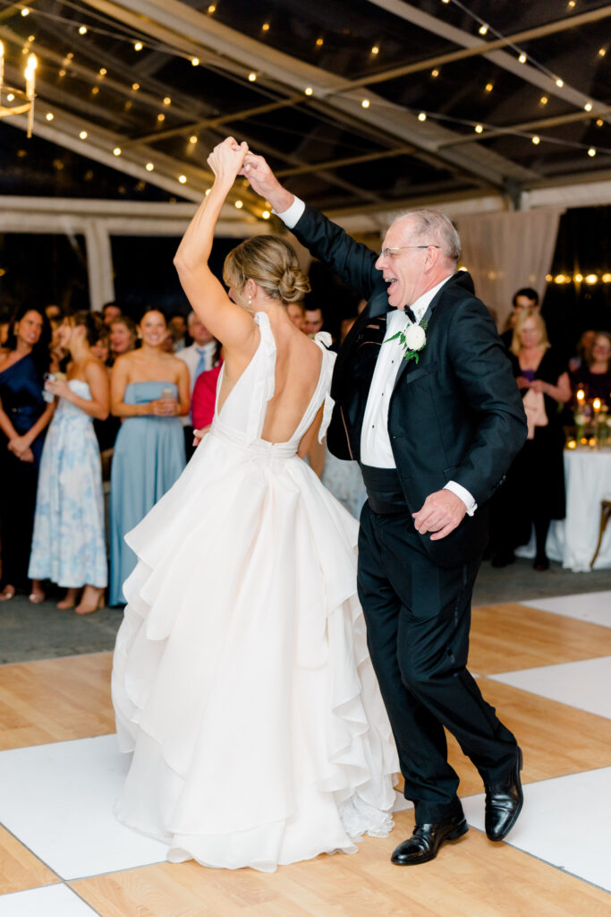 Father of the bride twists daughter during father-daughter dance.