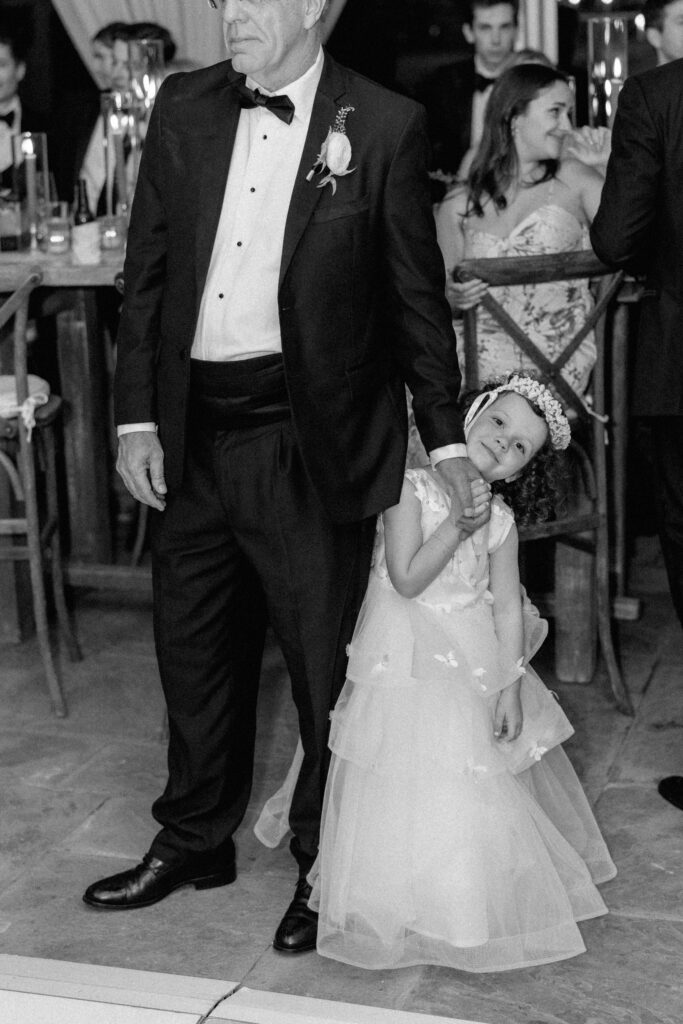 Flower girl holding grandfathers hand.