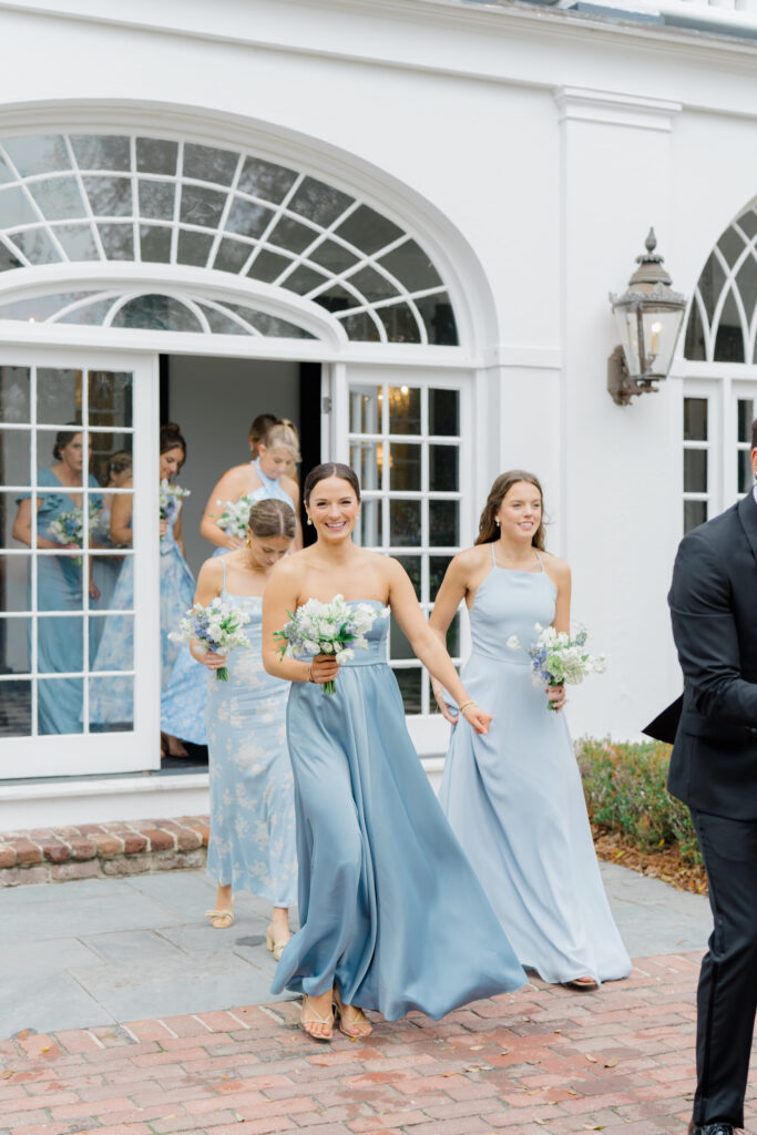 Bridesmaids walking out the door at Lowndes Grove. Candid wedding photos.