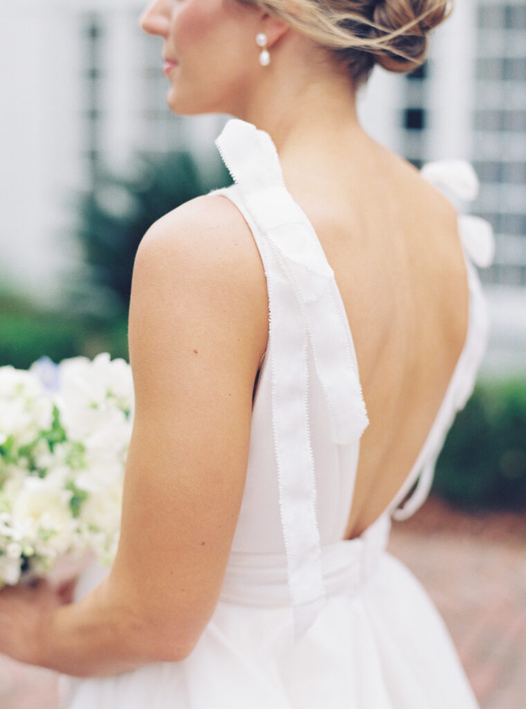 Wedding dress bows on brides shoulder. 