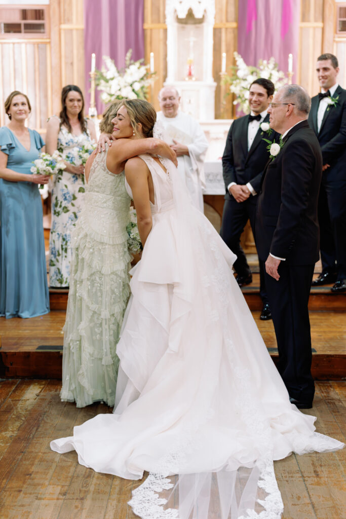 Bride hugs her mom before wedding ceremony. 