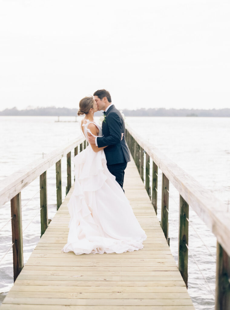 Bride and groom kiss on the dock at Lowndes Grove. Film photographer Charleston. 