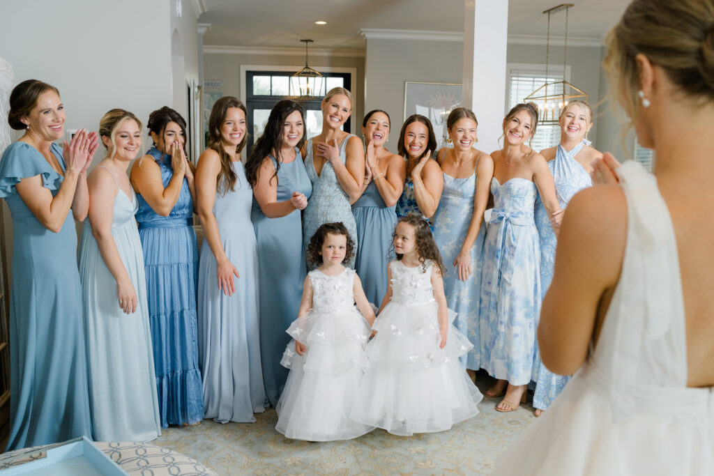 Bridesmaids in mix-matched tones and patterns of blue during first look with bride. 