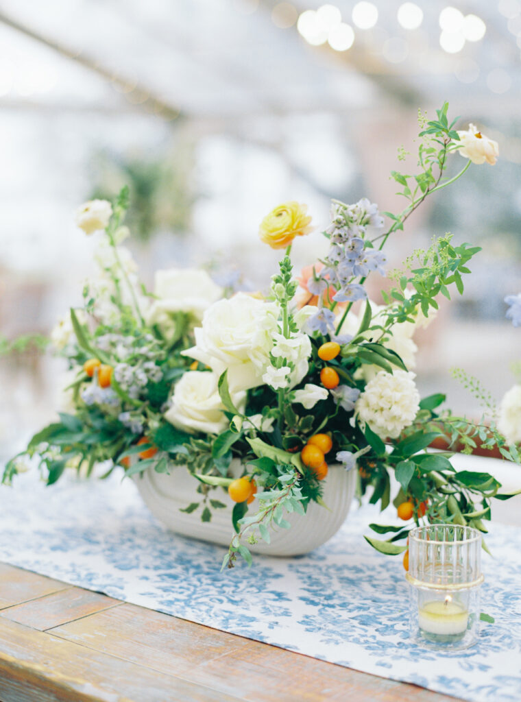 White and blue wedding reception flowers with kumquats. Pop of orange wedding flowers.