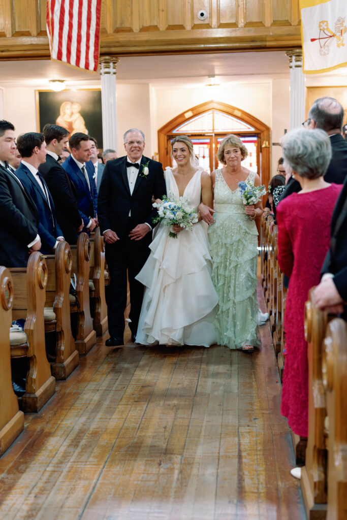 Bride walked up the aisle by both of her parents at Charleston spring wedding church ceremony. 