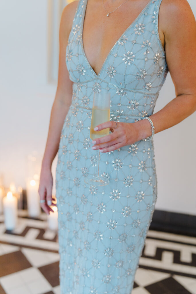 Wedding guest style at Charleston wedding. Wedding guest holding a glass of champagne.