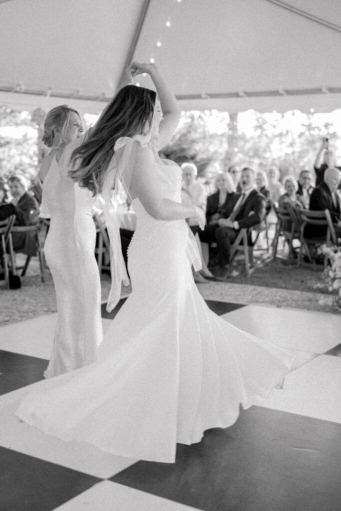 Bride twirled by her mom during wedding dance. 