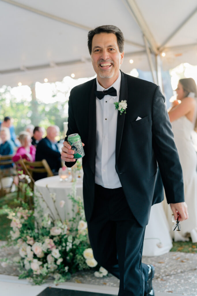 Father of the bride smiles after giving welcome speech. 