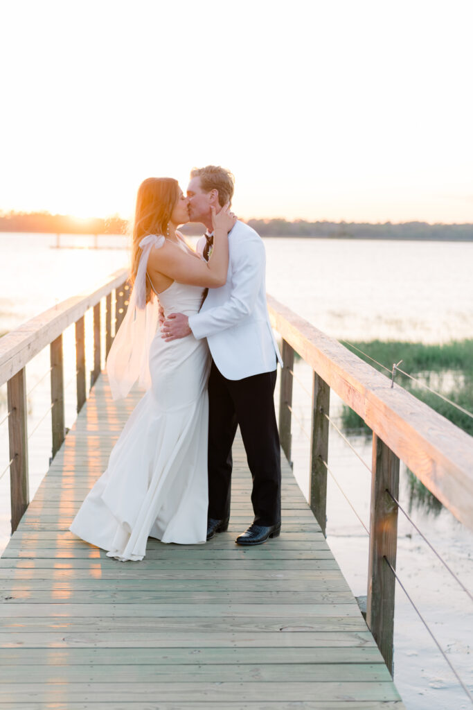 Bride and groom kiss on the dock at Lowndes Grove. 