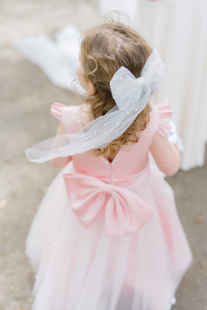 Pink flower girl dress with white bow and pearls. 