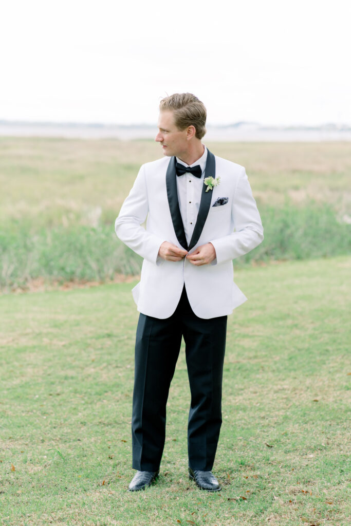 Groom in white tuxedo jacket and cayman boots. 