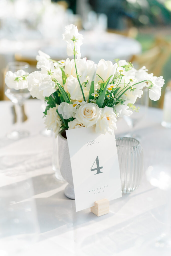 Table number with white tulips and roses. 