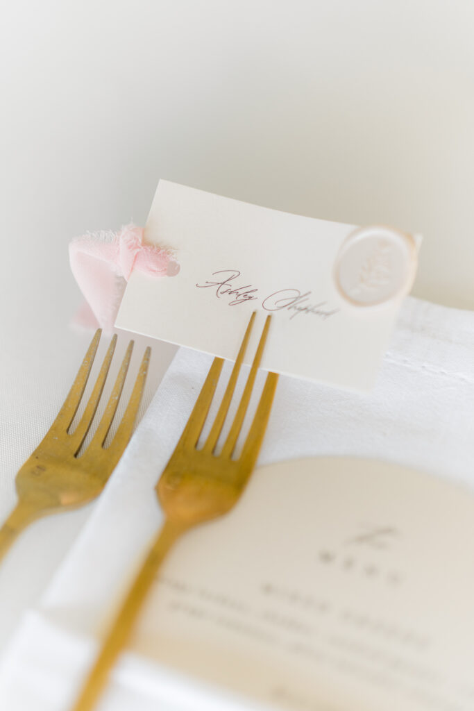 Gold forks with name card placed in tines. 