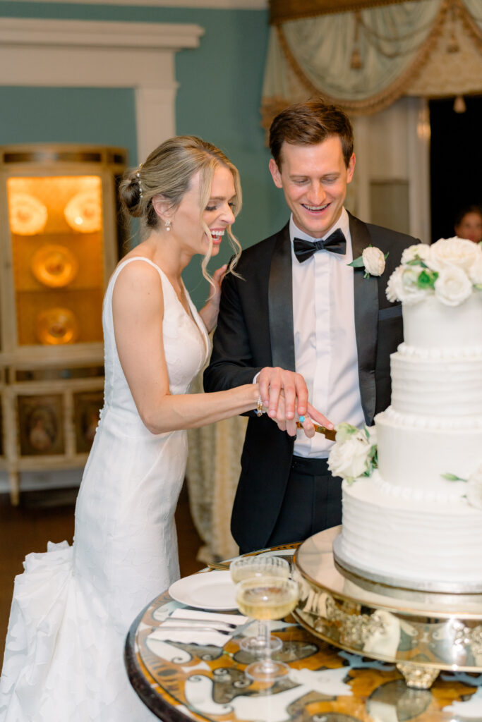 Bride and groom cake cutting at William Aiken House. Four-tiered wedding cake. 
