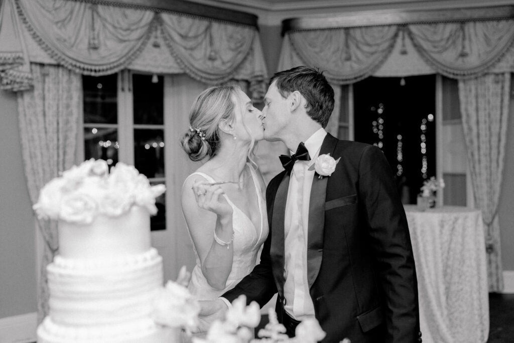 Bride and groom kiss after cake cutting.