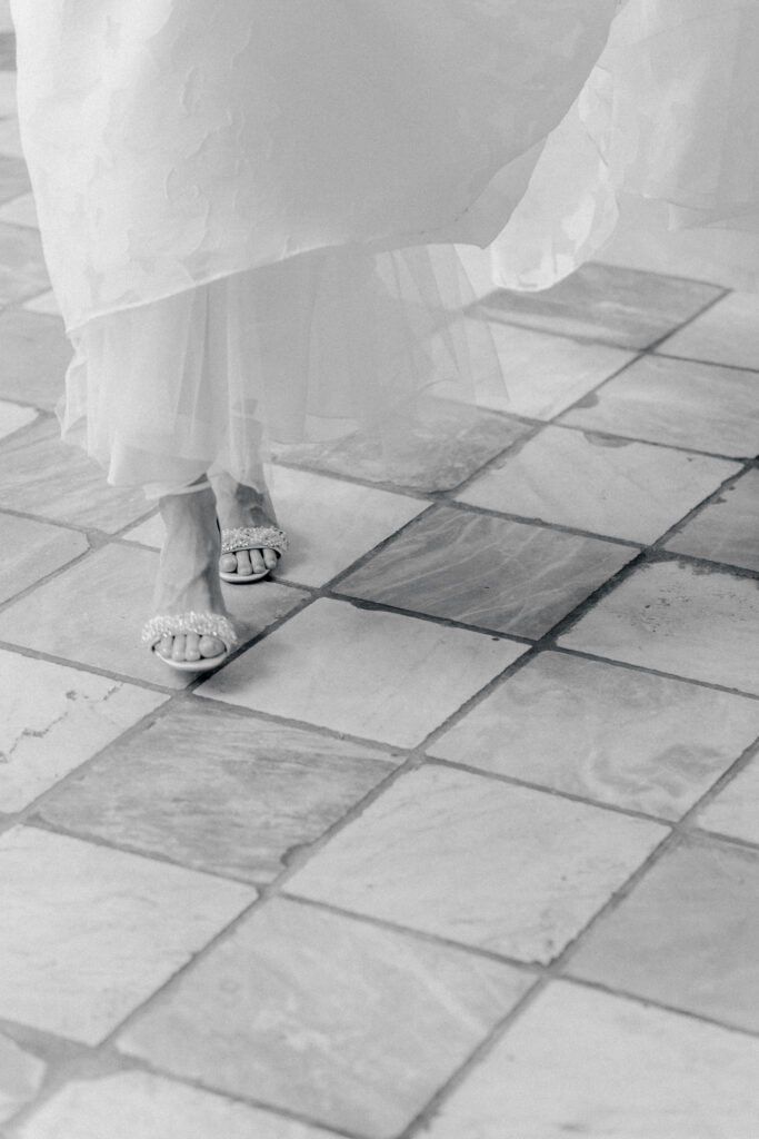 Bride's sparkly shoes walking on the checkerboard floor at William Aiken House. 