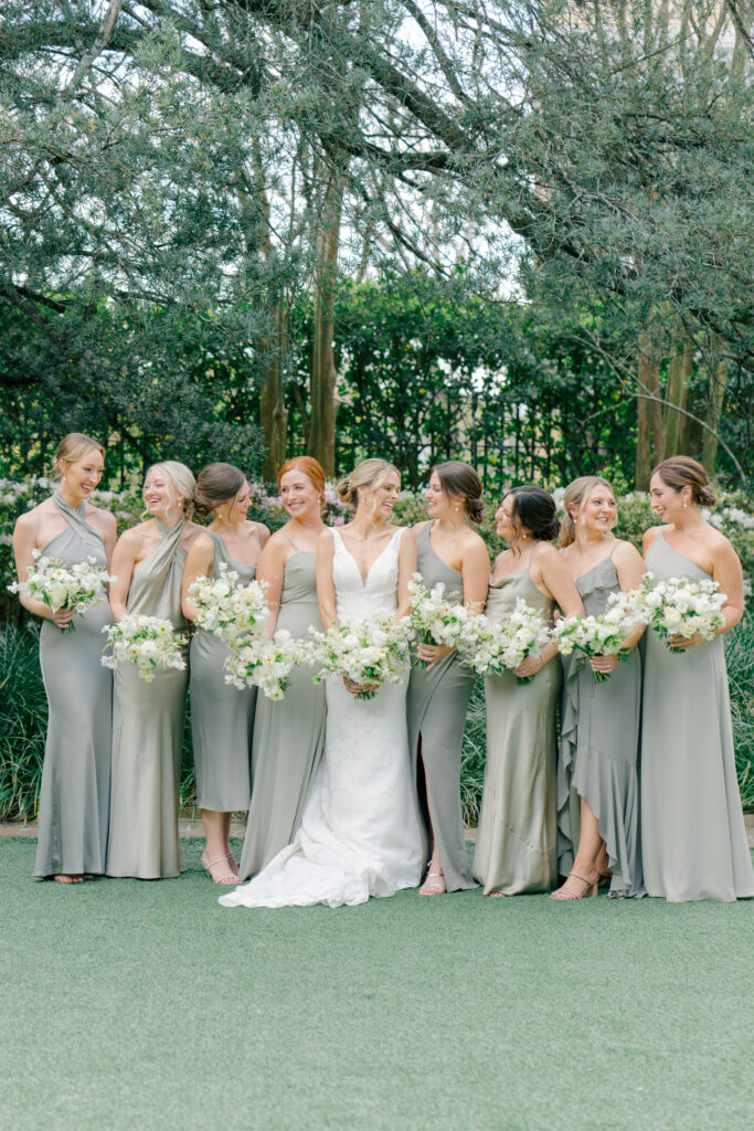 Bride with bridesmaids. Bridesmaids in muted green dresses and classic white flowers. Perfect spring day in Charleston. 