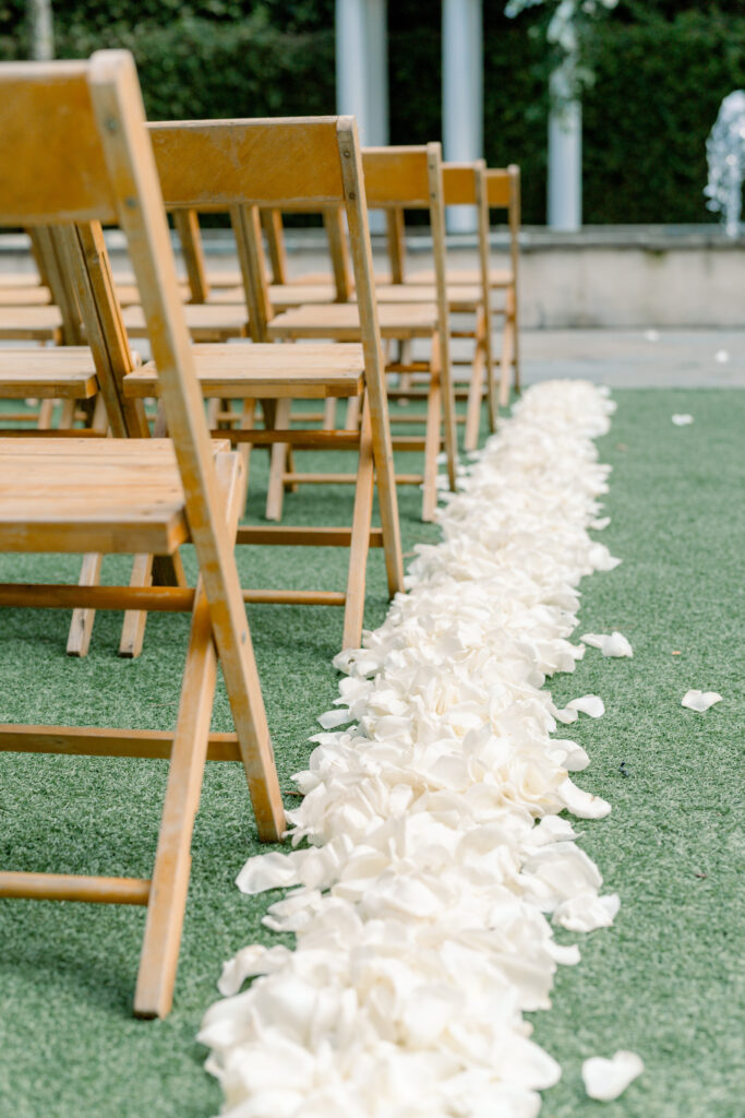 White rose petals lining the aisle at outdoor spring wedding ceremony in Charleston. 
