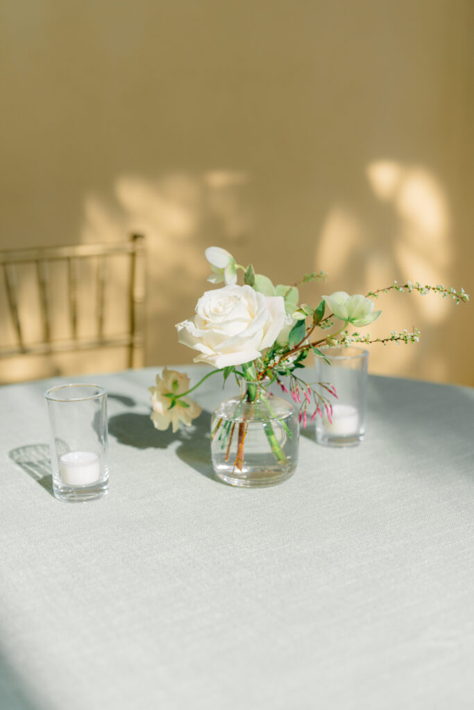 White and green small whimsical table top flowers. Shadow play wedding day details. 