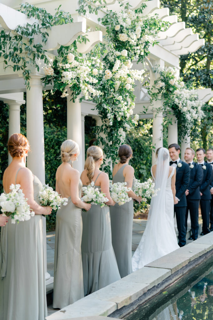 Perfect wedding ceremony at William Aiken House. Sun kissing the flowers decorating the pergola. Charleston wedding photographer. 